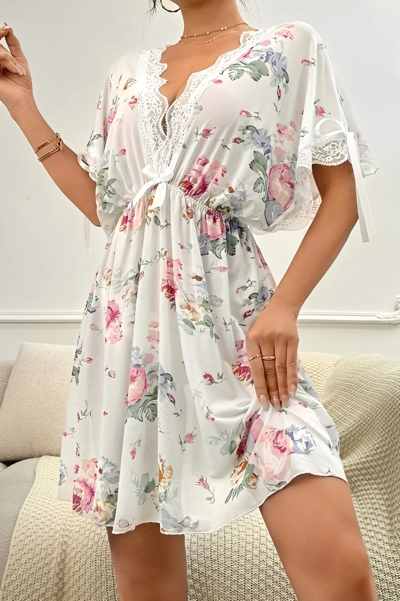 Model wearing a custom white lace pajama set featuring a floral print, V-neckline, lace trim, and short flutter sleeves for a soft and feminine sleepwear look.