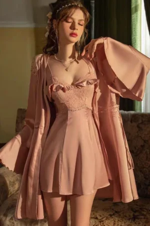 Model wearing a pink satin nightdress with lace bodice and matching robe, shown as a b2b sexy nightgown for women