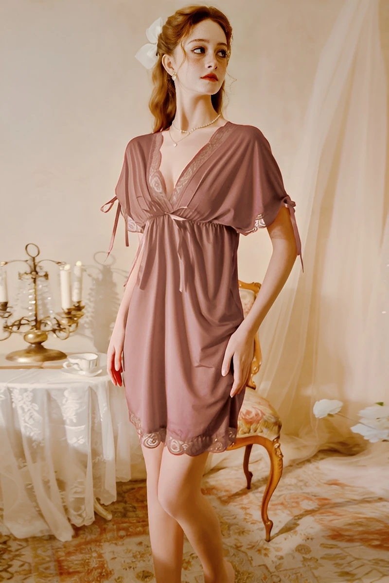 Model wearing a khaki brown lace pajama set with lace trim, short sleeves, and flowing hemline in a classic interior setting.