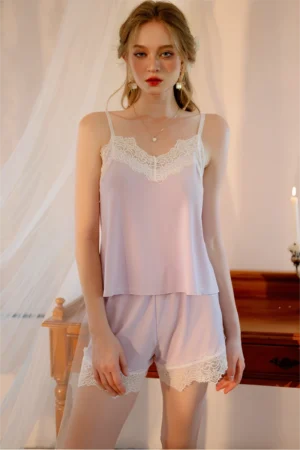 Model wearing a soft pink lace pajama short set featuring a lace camisole top and matching shorts for women’s sleepwear collections
