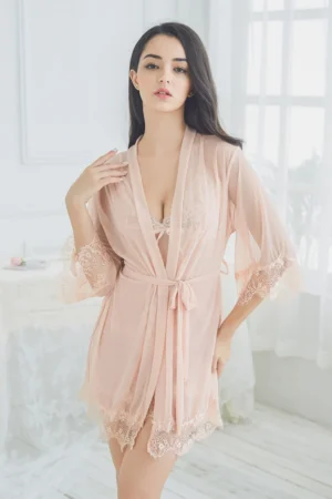 Model wearing a blush pink wholesale sexy see through nightgown with sheer mesh fabric, lace cuffs, and matching robe, front view.